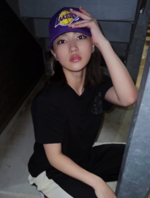 Hinata modeling outdoors in a cap and a black t-shirt